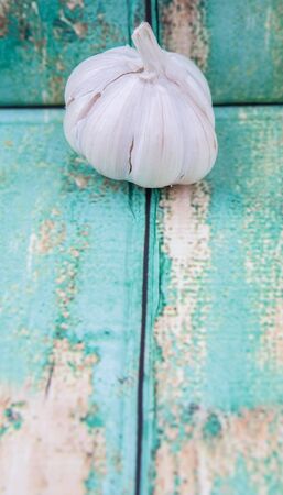 A clove of garlic over rustic wooden backgroundの写真素材
