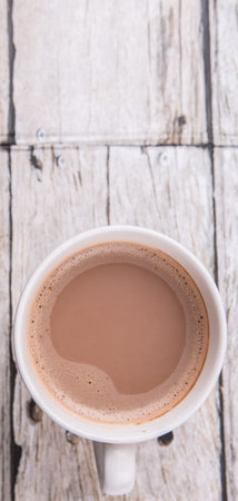 A mug of hot chocolate over wooden background