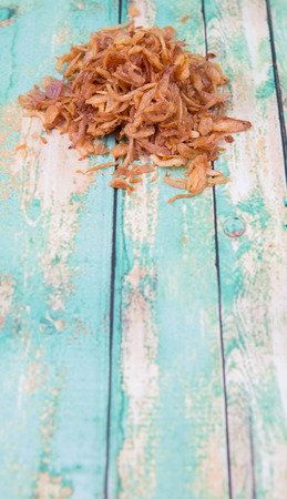 Deep fried shallots for garnishing over wooden backgroundの写真素材