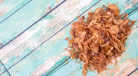 Deep fried shallots for garnishing over wooden backgroundの写真素材