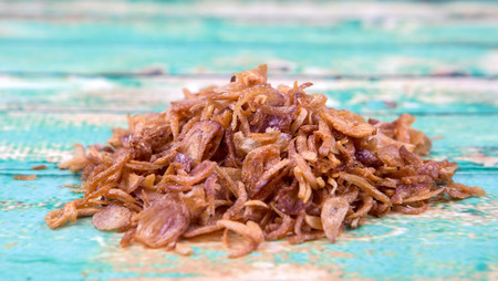 Deep fried shallots for garnishing over wooden backgroundの写真素材