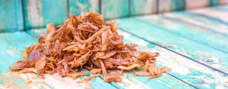 Deep fried shallots for garnishing over wooden backgroundの写真素材