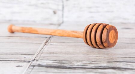 Wooden honey dipper over wooden backgroundの写真素材