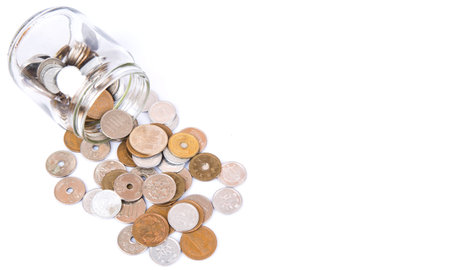 Japanese Yen coins in a mason jar over white background