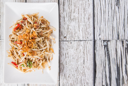 Malaysian dish bean sprout salad or local name Kerabu Taugeh in a white plate over wooden backgroundの写真素材