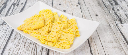 Malaysian dish Net Pancake or locally known as Roti Jala on white plate over wooden background