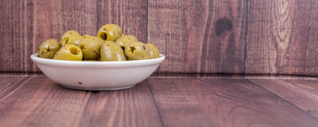 Pickled olive in a white bowl over white backgroundの写真素材