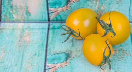 Mini yellow cherry tomatoes over wooden backgroundの写真素材