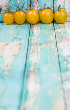 Mini yellow cherry tomato over wooden backgroundの写真素材