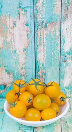 Mini yellow cherry tomatoes over wooden backgroundの写真素材