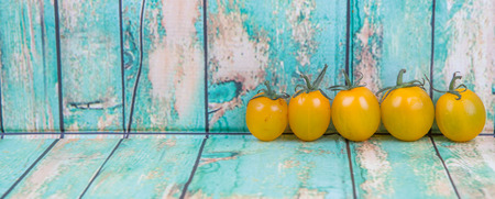 Mini yellow cherry tomatoes over wooden backgroundの写真素材