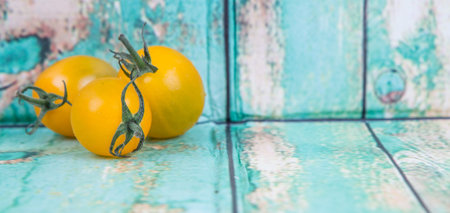 Mini yellow cherry tomatoes over wooden backgroundの写真素材
