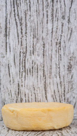 Round cheese over wooden backgroundの写真素材