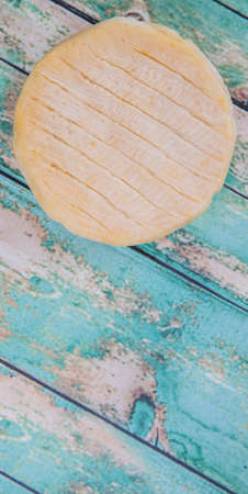 Round cheese over wooden backgroundの写真素材