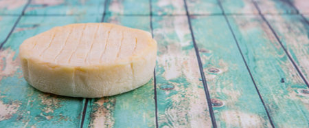 Round cheese over wooden backgroundの写真素材