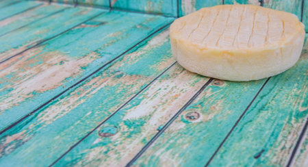Round cheese over wooden background