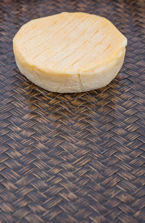 Round cheese on wicker backgroundの写真素材