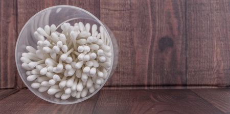 White cotton bud or cotton swab over wooden background