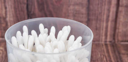 White cotton bud or cotton swab over wooden backgroundの写真素材