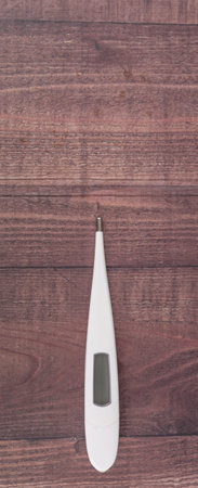 Medical thermometer over wooden background