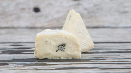 Blue cheese over wooden backgroundの写真素材