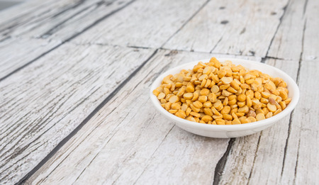 Raw Indian dhal in white bowl over wooden backgroundの写真素材