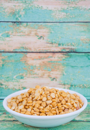 Raw Indian dhal in white bowl over wooden backgroundの写真素材