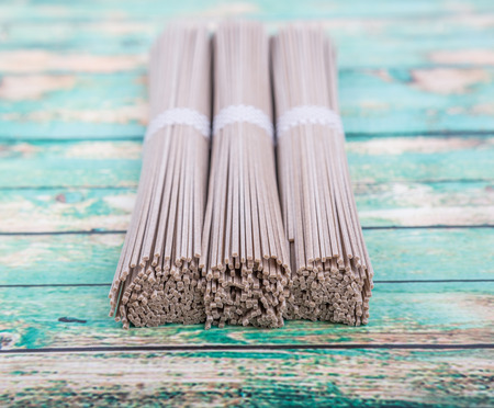 Dried raw soba noodle stick over wooden backgroundの写真素材