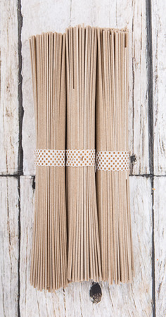 Dried raw soba noodle stick over wooden backgroundの写真素材