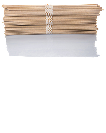 Dried raw Japanese soba noodle stick over white backgroundの写真素材