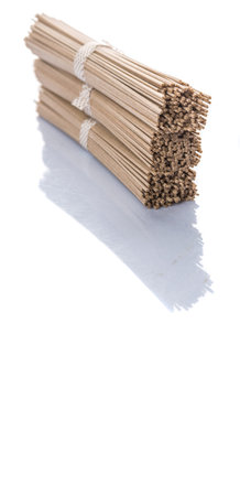Dried raw Japanese soba noodle stick over white backgroundの写真素材