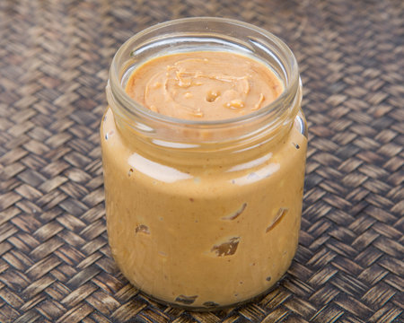 Peanut butter in a mason jar over wicker background
