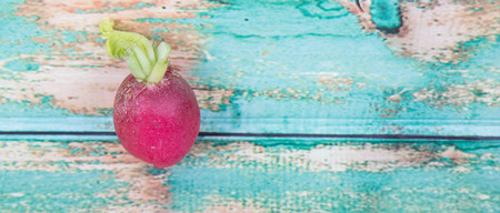 Small red radish vegetable over wooden backgroundの写真素材