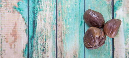 Roasted whole peeled chestnut over wooden backgroundの写真素材