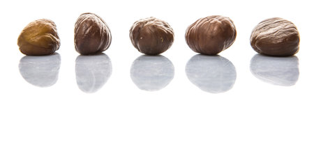 Roasted whole peeled chestnut over white background
