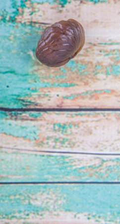Roasted whole peeled chestnut over wooden background