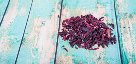 Dried red hibiscus tea leaves over wooden backgroundの写真素材