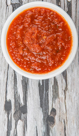 Spaghetti sauce in a white bowl over wooden backgroundの写真素材