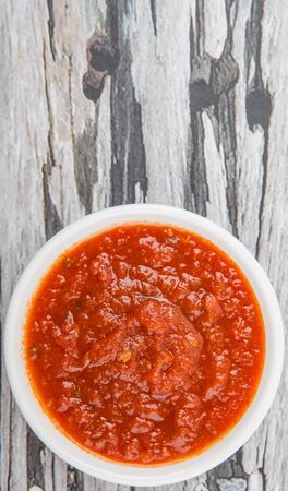 Spaghetti sauce in a white bowl over wooden backgroundの写真素材