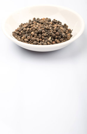 Dried lemon balm leaves in white bowl over white background