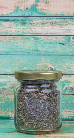 Dried lemon balm leaves in mason jar over wooden backgroundの写真素材
