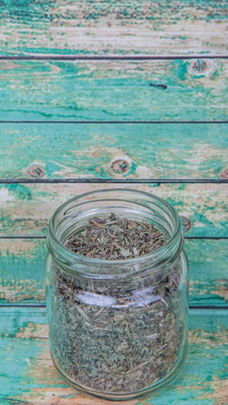 Dried lemon balm leaves in mason jar over wooden backgroundの写真素材