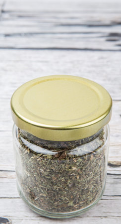 Dried lemon balm leaves in mason jar over wooden backgroundの写真素材