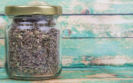 Dried lemon balm leaves in mason jar over wooden backgroundの写真素材