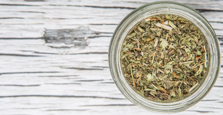 Dried lemon balm leaves in mason jar over wooden backgroundの写真素材