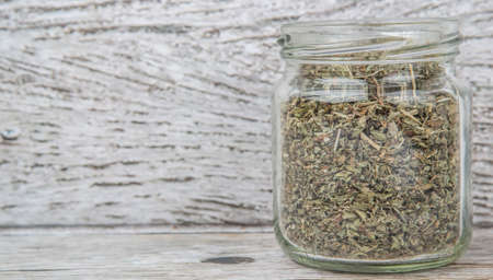 Dried lemon balm leaves in mason jar over wooden backgroundの写真素材