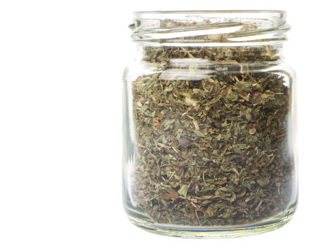 Dried lemon balm leaves in a mason jar over white backgroundの写真素材