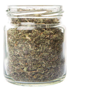 Dried lemon balm leaves in a mason jar over white backgroundの写真素材