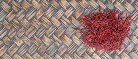 Dried saffron spices over wicker backgroundの写真素材