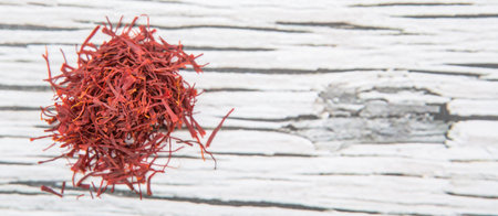 Dried saffron spice over wooden background